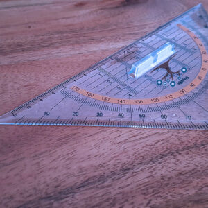 A protractor and pencil on a wood surface.
