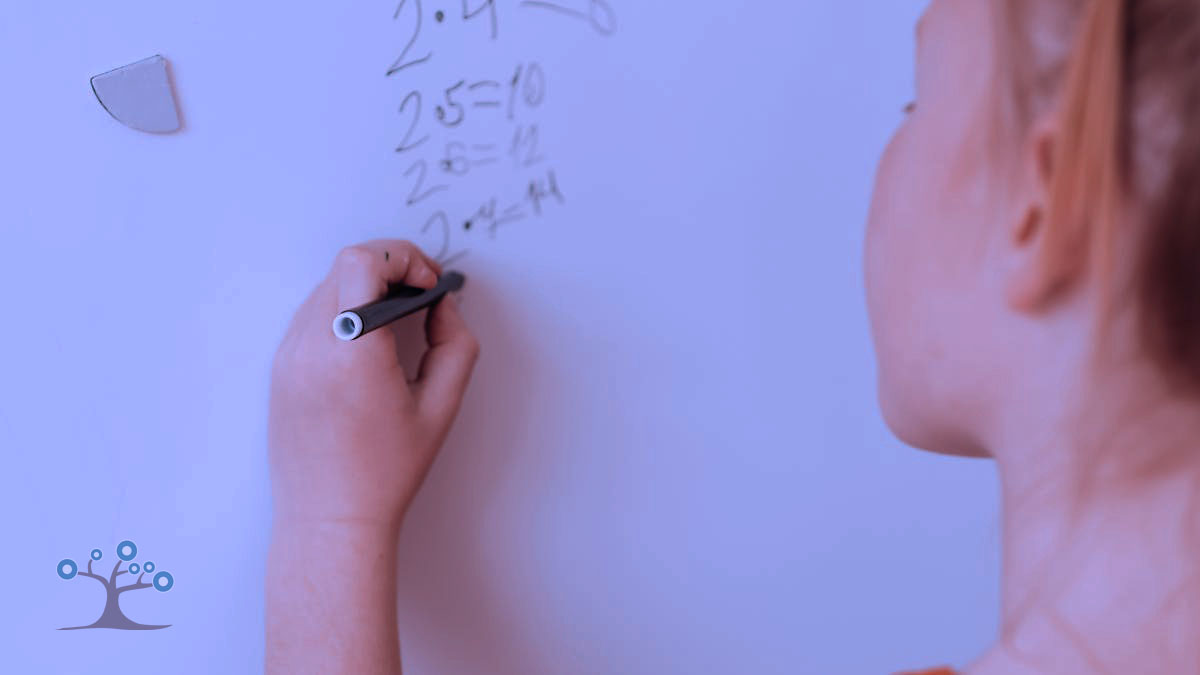 A girl writing math problems with a marker and a white board.