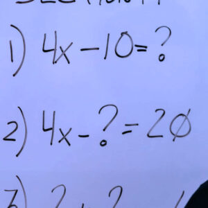 A whiteboard with algebra problems on it.