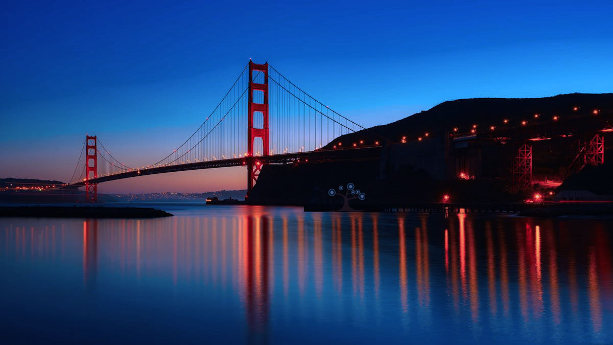 An evening photo of the Golden Gate bridge with a reflection on the water.