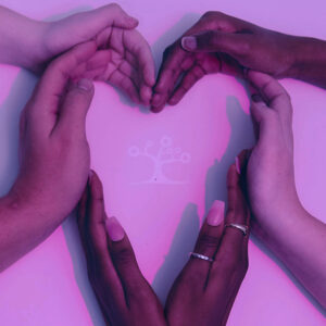 Four hands of different skin tones form a heart on a light pink surface, reflecting unity, love, and the core values highlighted in the Ethnic Studies product.