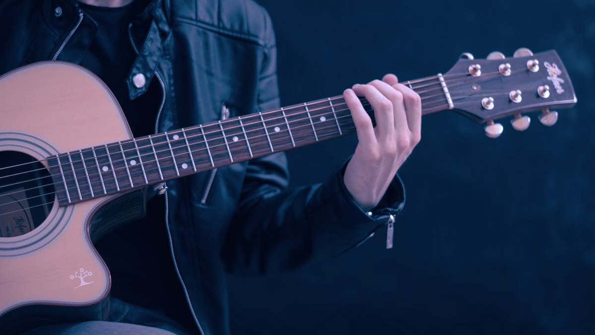 Hand placed on a guitar fret