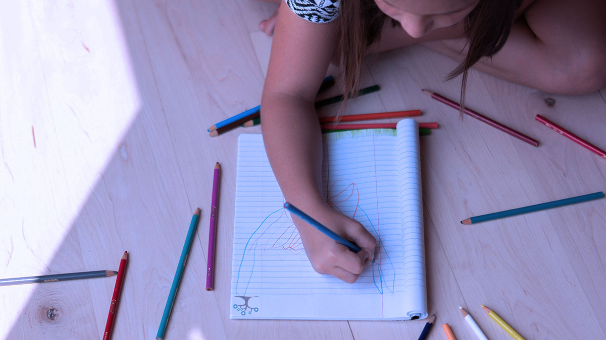 Young girl coloring in a workbook with pencils